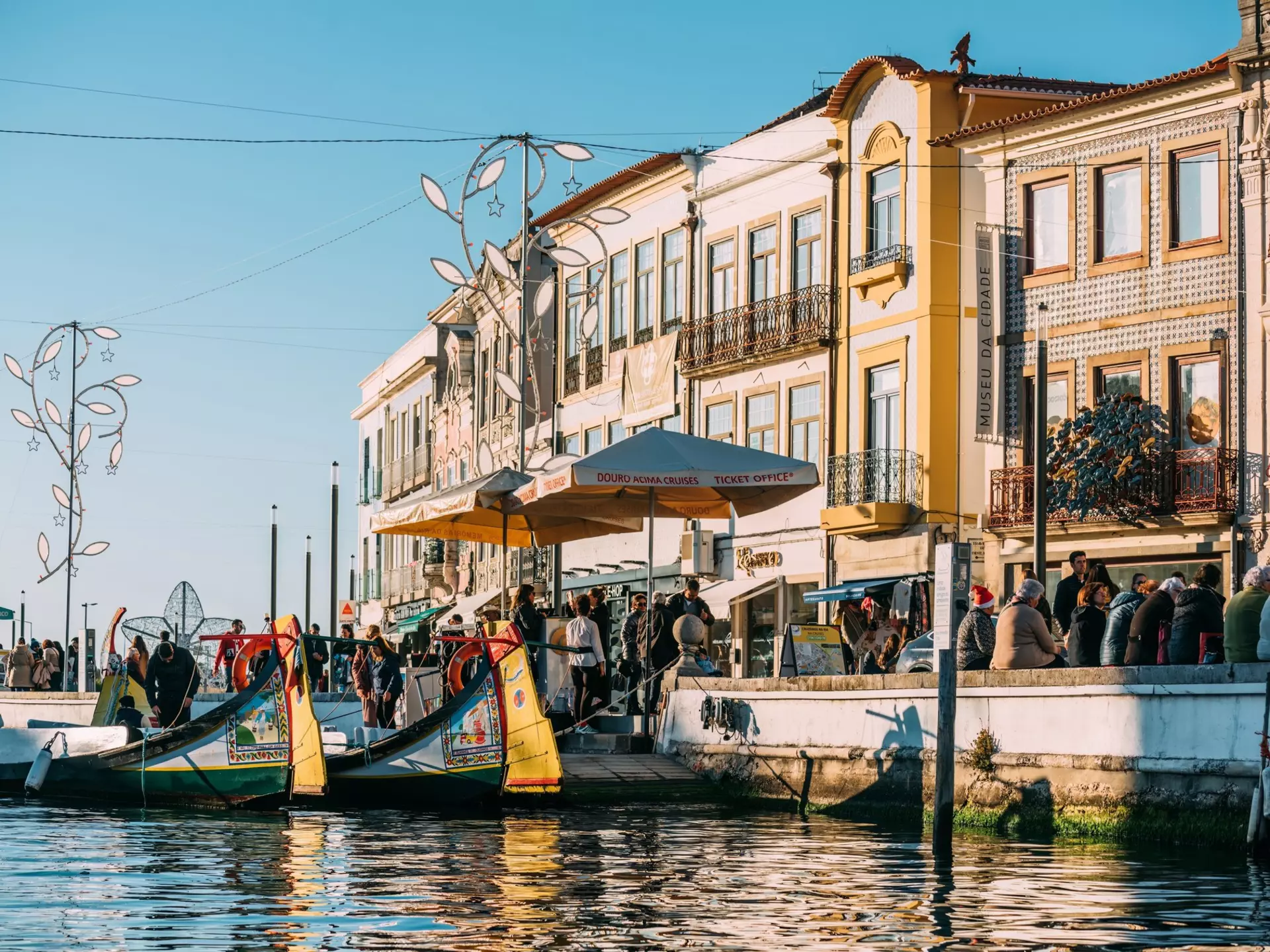 Colorful traditional boat docked in Aveiro, Portugal with vibrant architecture in the background.