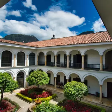 Interior garden of Museo Botero with a view of Monserrate in the background, on a cloudy day in Colombia.