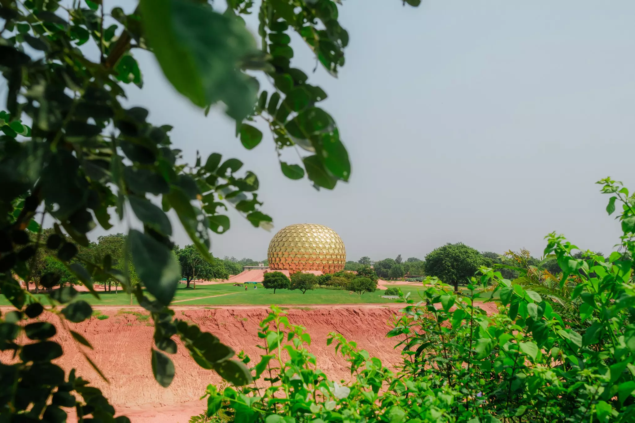 A large gold dome in the center of a rural landscape