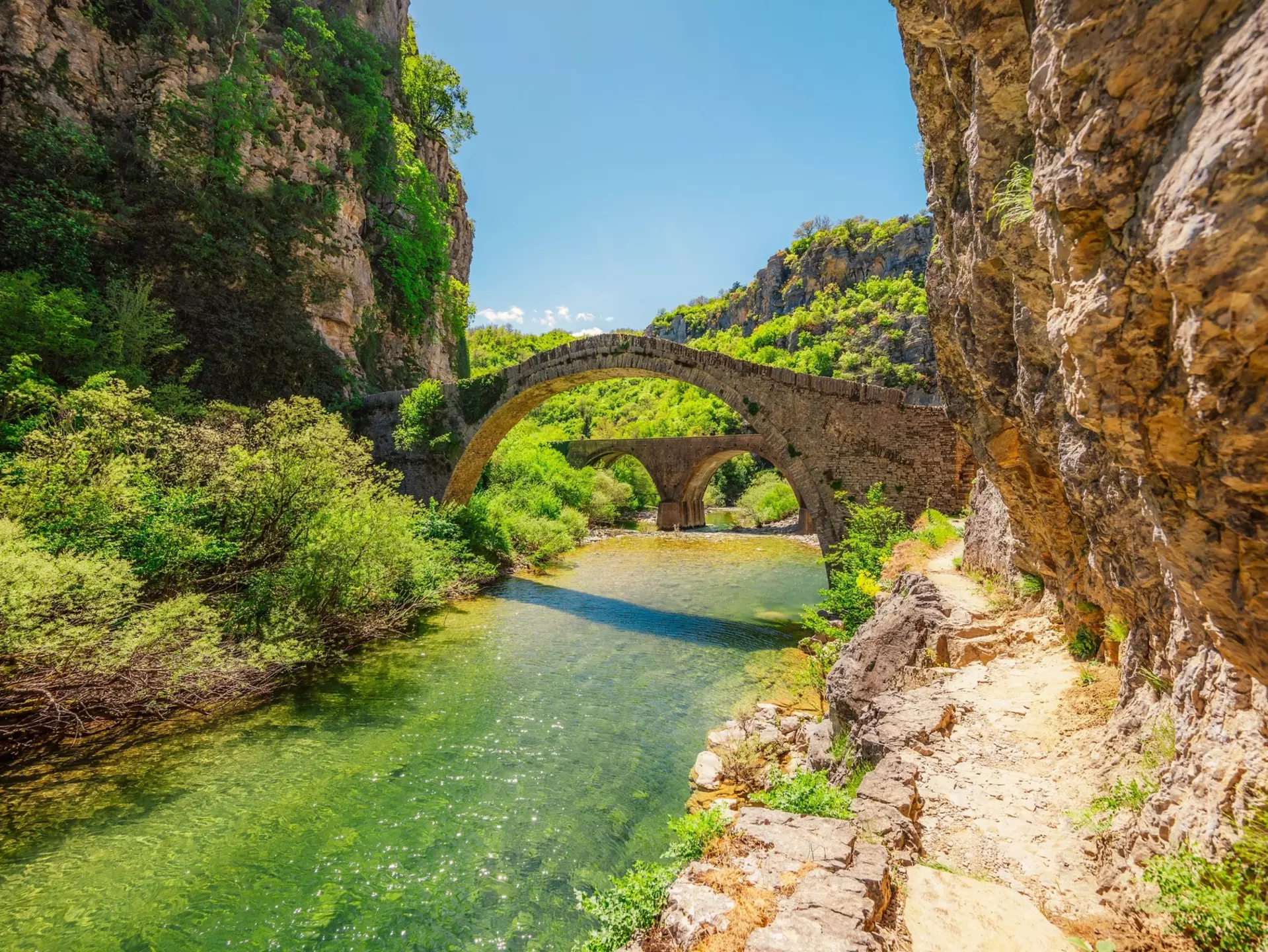 Kokkorou bridge, medieval stone bridge on river of Voidomatis, Pindus Mountains, Zagori, Greece. zedspider / Shutterstock