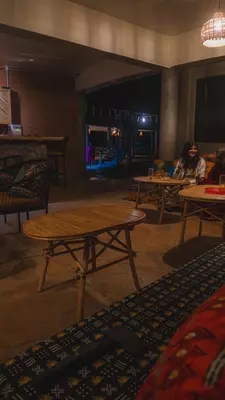 A dark room with two women sat chatting on a long bench of cushioned seats