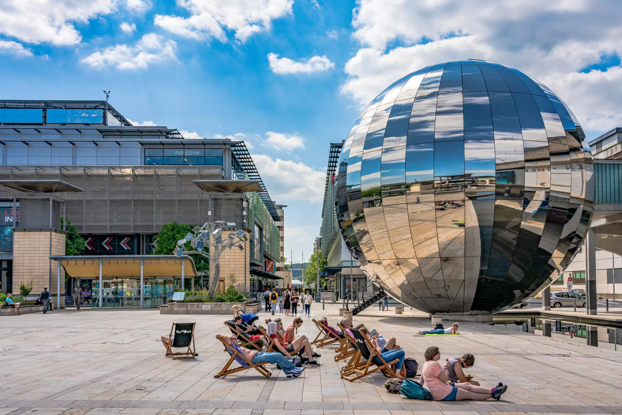 People sit in front of a large disco-ball sculpture at We The Curious in Bristol.