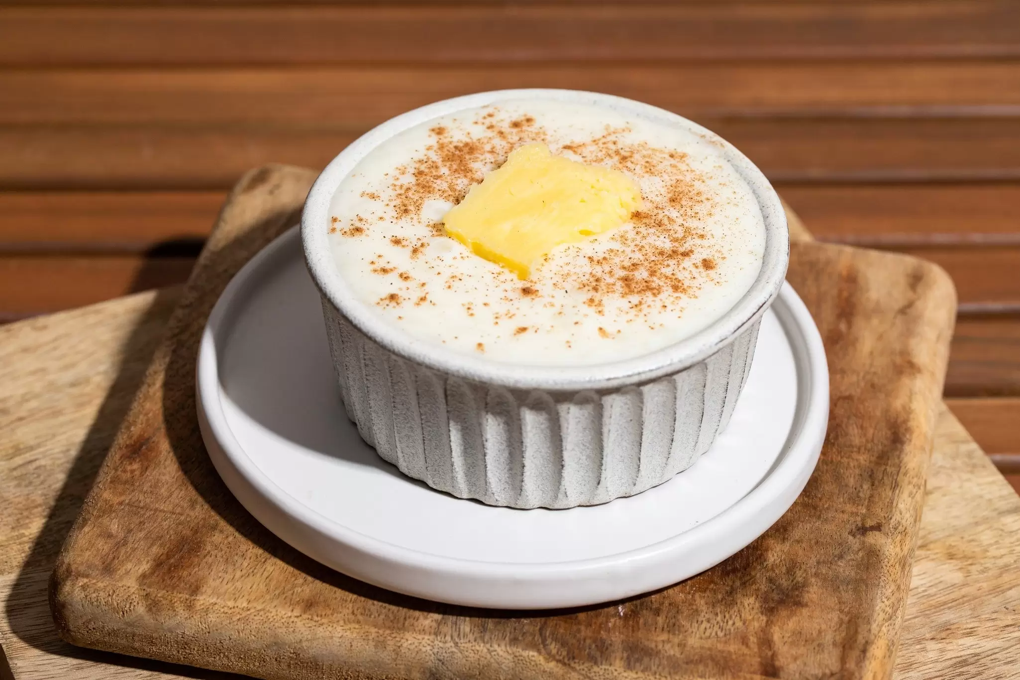 Close up of Risengrod bowl  with butter and cinnamon on wooden table., License Type: media, Download Time: 2025-02-07T14:32:44.000Z, User: meg3348277, Editorial: false, purchase_order: 56530 - Guidebooks, job: Global Publishing-WIP, client: Denmark & the Faroe Islands 10, other: Megan Cassidy