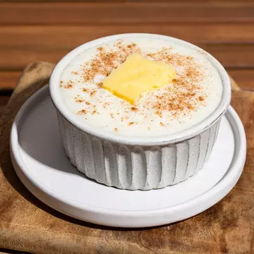 Close up of Risengrod bowl  with butter and cinnamon on wooden table., License Type: media, Download Time: 2025-02-07T14:32:44.000Z, User: meg3348277, Editorial: false, purchase_order: 56530 - Guidebooks, job: Global Publishing-WIP, client: Denmark & the Faroe Islands 10, other: Megan Cassidy