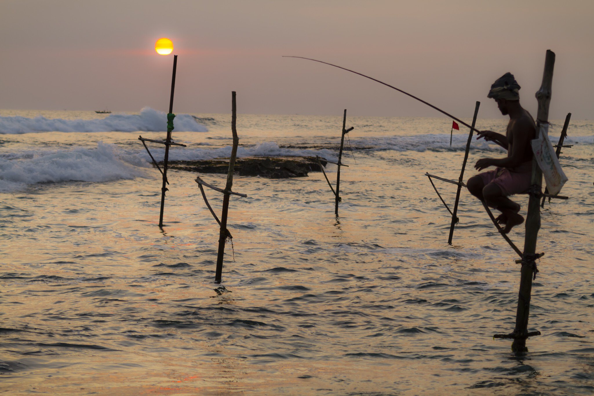 Man fishing from stilt at sunset, Unawatuna, Sri Lanka