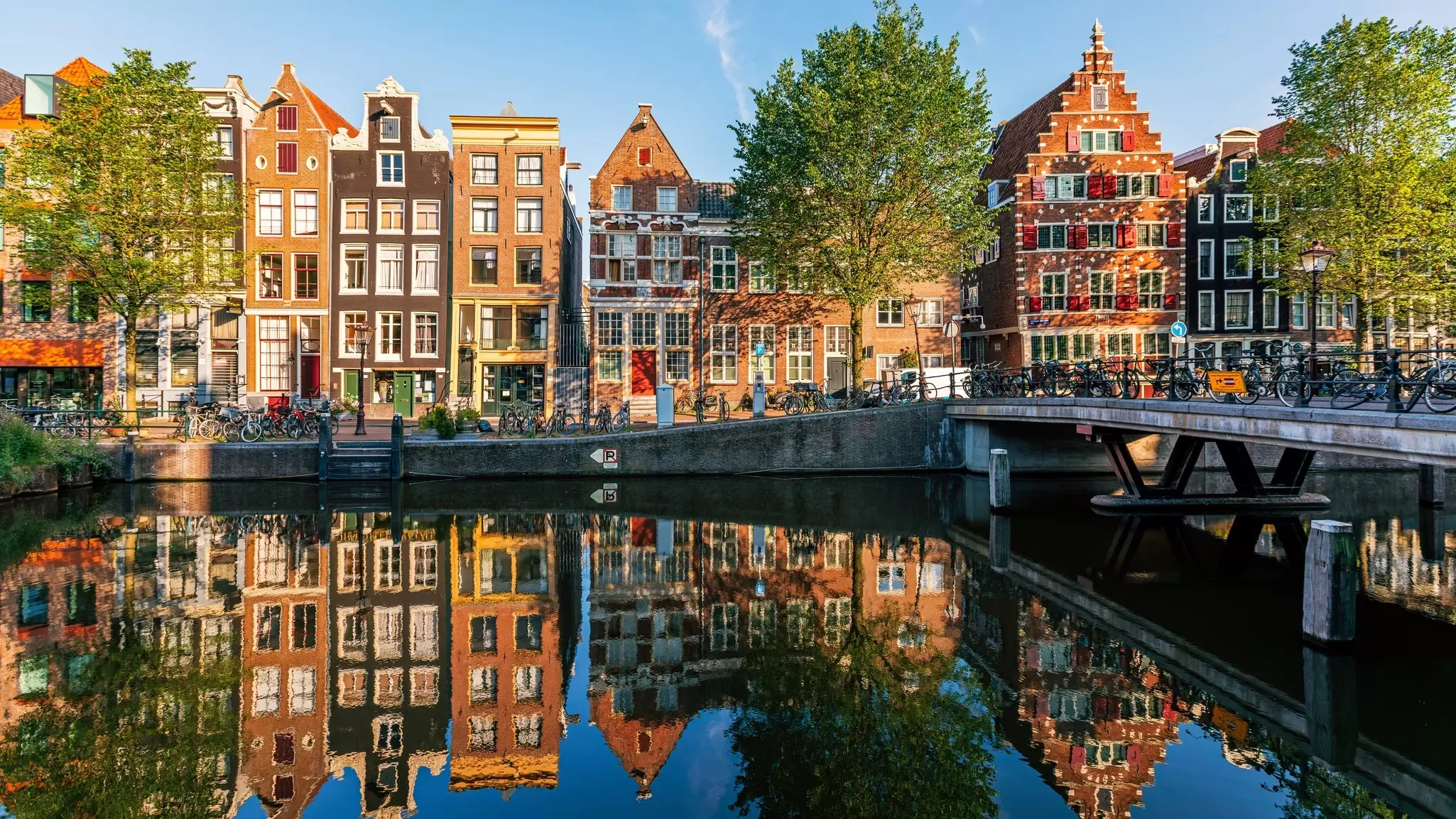 Historic Dutch houses reflected in the canal, Amsterdam. Alexander Spatari/Getty Images