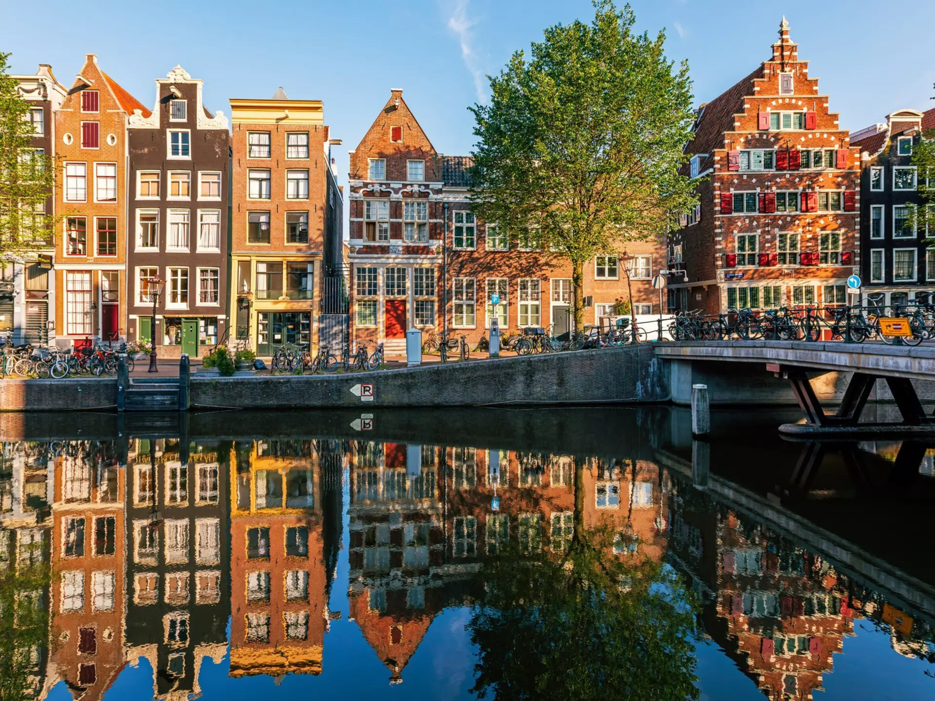 Historic Dutch houses reflected in the canal, Amsterdam. Alexander Spatari/Getty Images