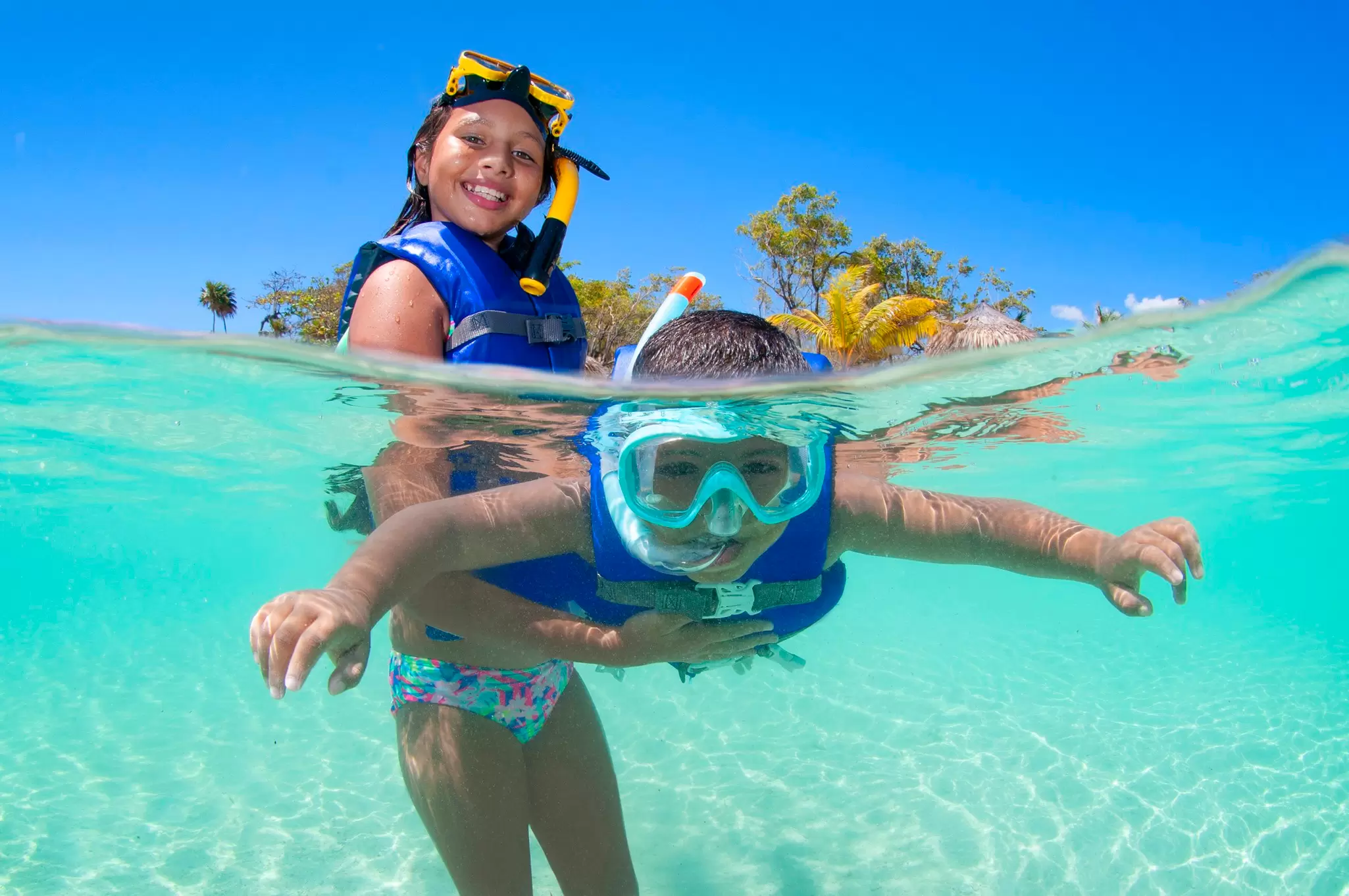 Young girl holding her brother in surface and helping him snorkelling.
1167009676
