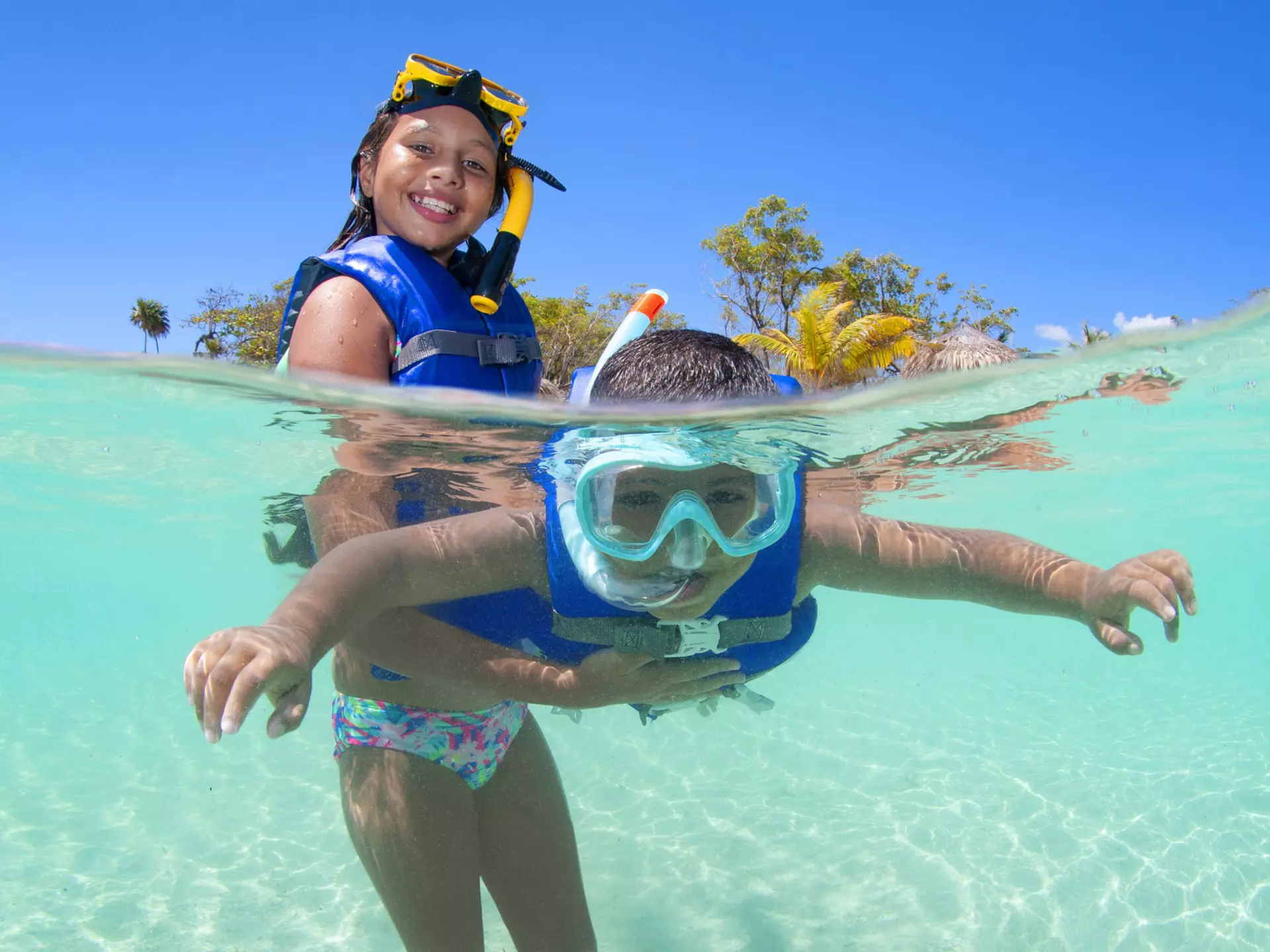 Young girl holding her brother in surface and helping him snorkelling.
1167009676