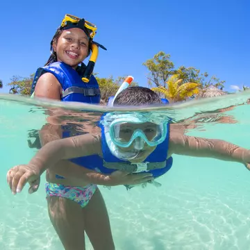 Young girl holding her brother in surface and helping him snorkelling.
1167009676