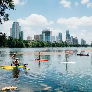 View of the city skyline at sunset across the Lady Bird River in Austin, Texas.