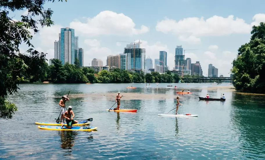 View of the city skyline at sunset across the Lady Bird River in Austin, Texas.