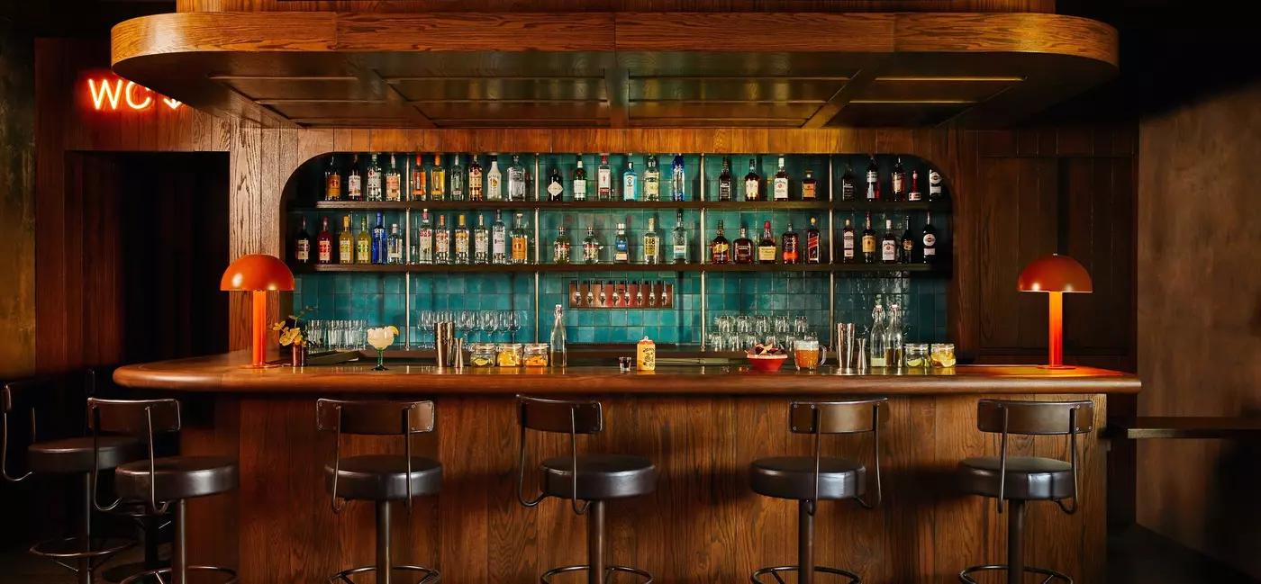 Bar at the on-site Miss Kitty's restaurant, with a wood-build and a turquoise tile backsplash.