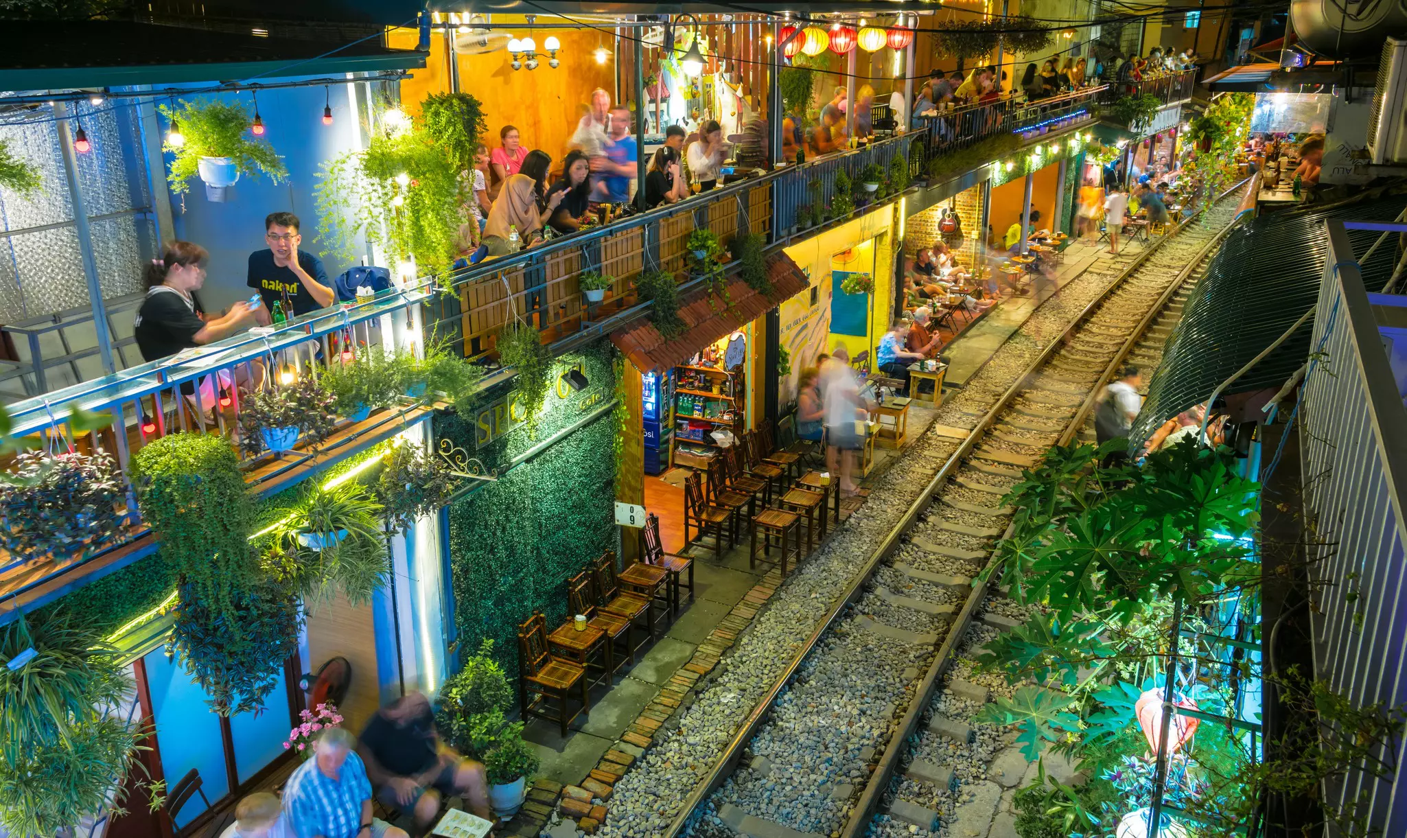 The outside of a cafe, right along the train tracks.