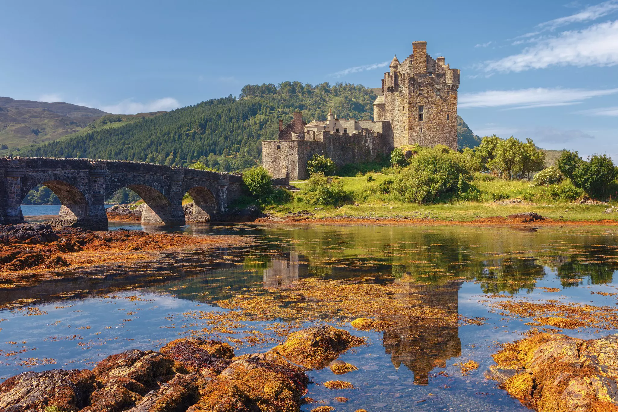 Exterior of the Eilean Donan Castle and nearby stone bridge, at the entrance of Loch Duich, Scotland.