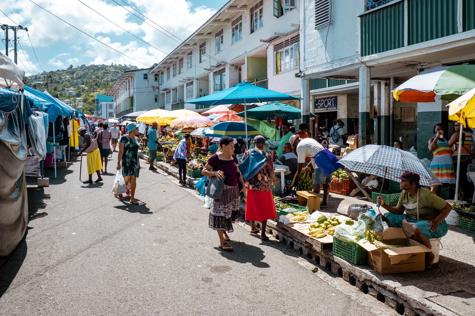 People shop at a street market selling fresh produce.