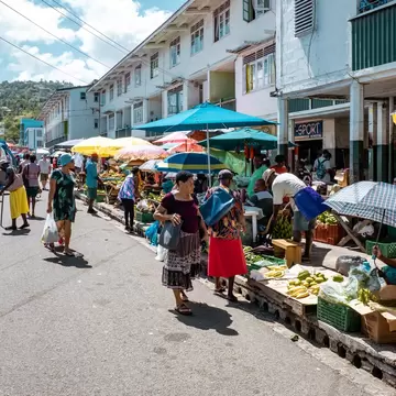 People shop at a street market selling fresh produce.