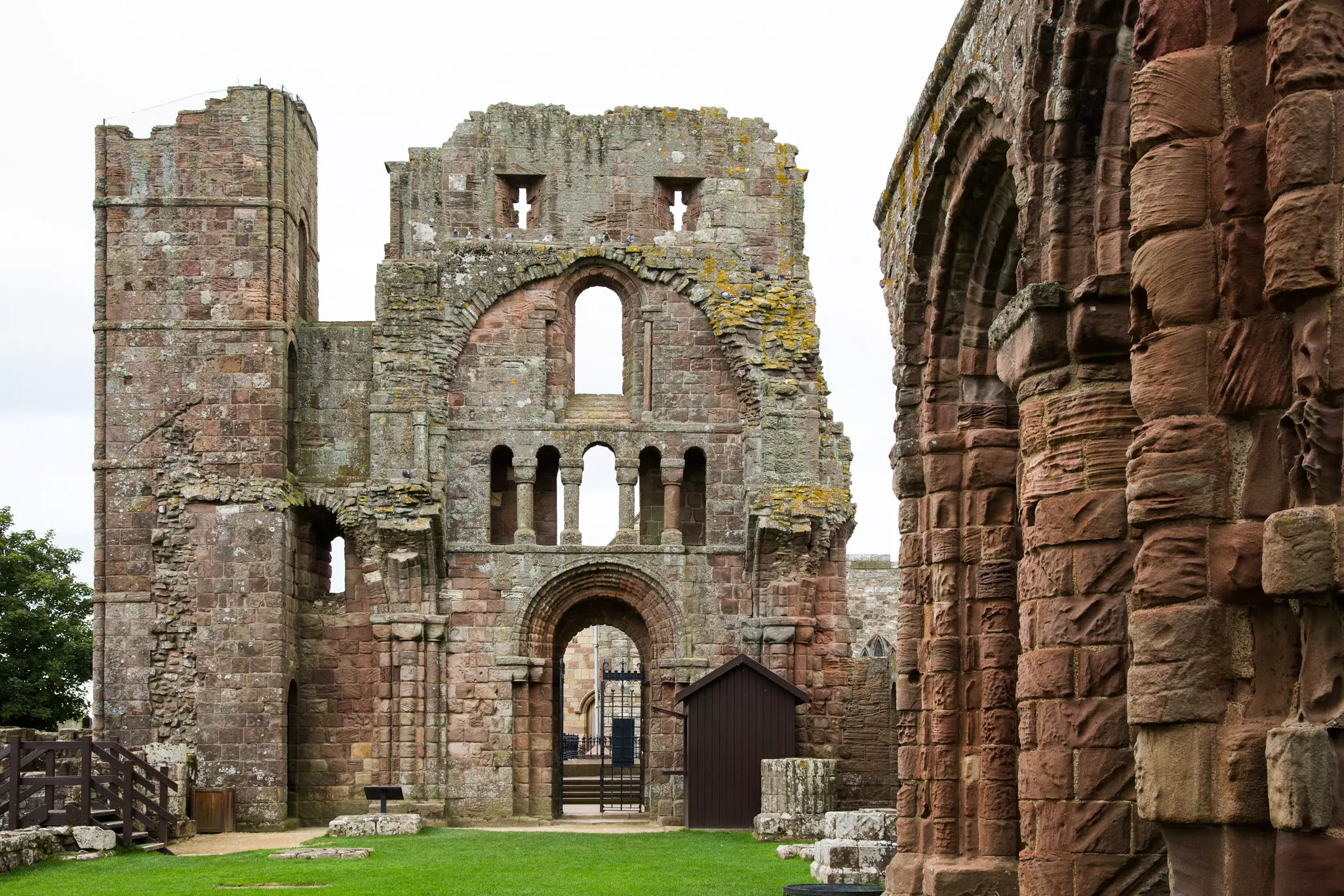 A ruined priory building with crumbling stonework on a tall tower.