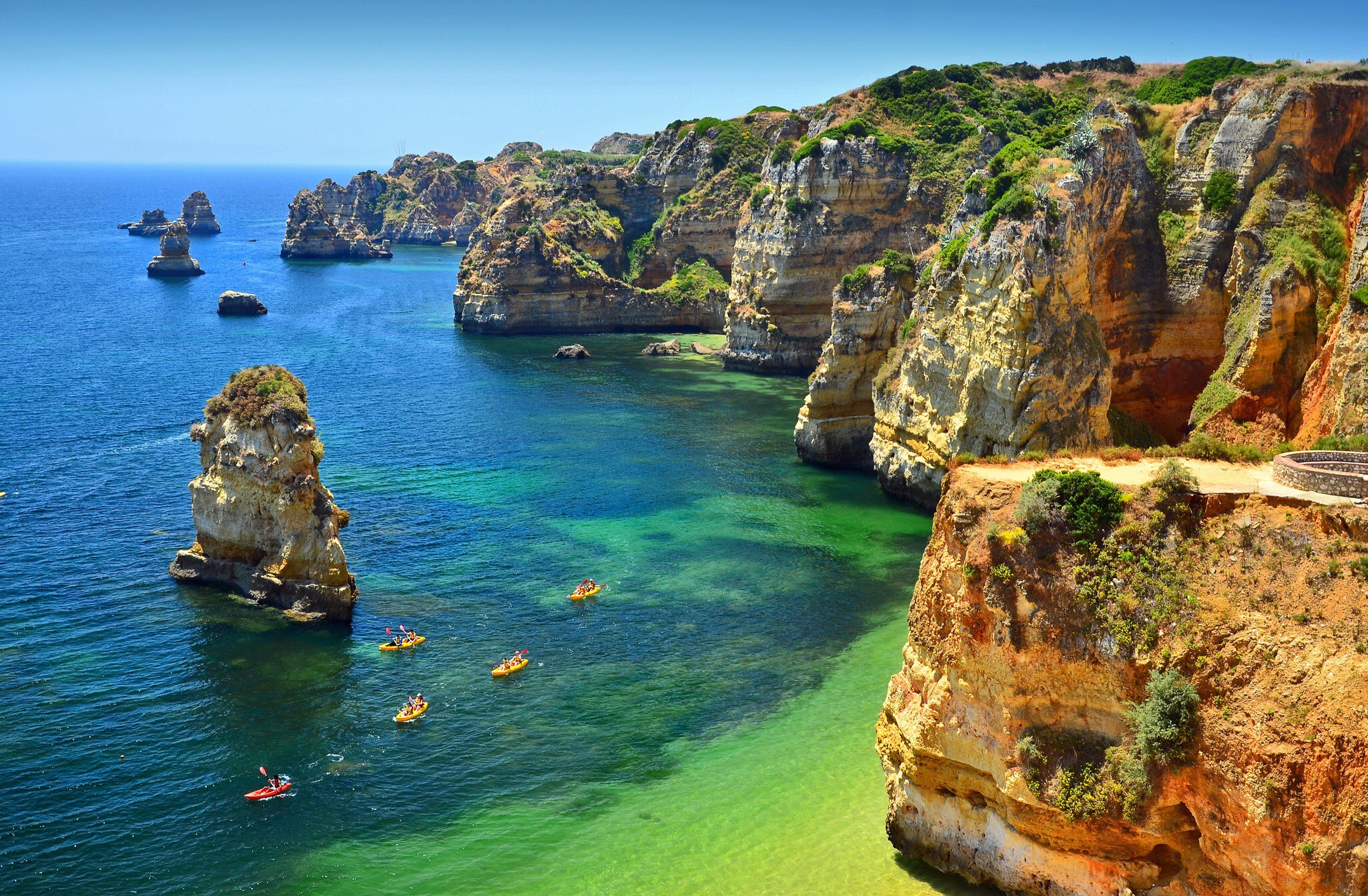 Group of kayaks navigate through these crystal waters of Praia Dona Ana, Lagos. Portuguese Algarve.