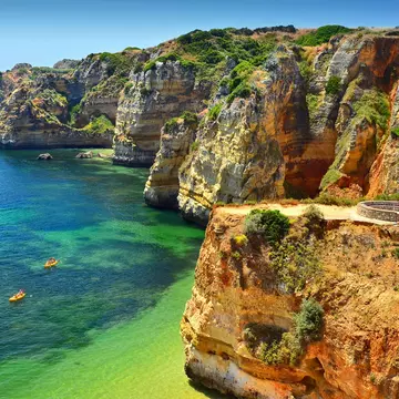 Group of kayaks navigate through these crystal waters of Praia Dona Ana, Lagos. Portuguese Algarve.