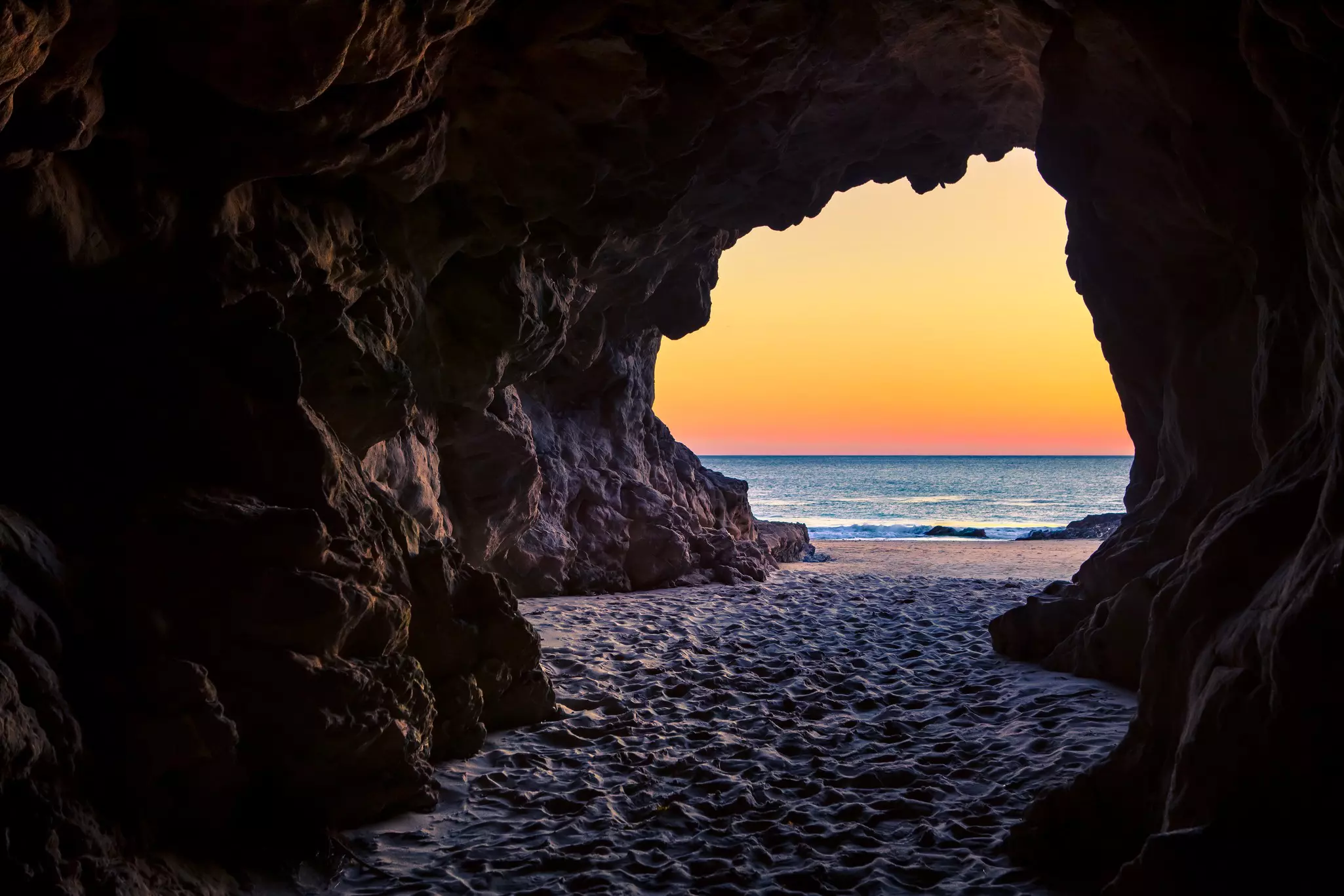 A view of Leo Carillo State Beach from a cave at sunset. 