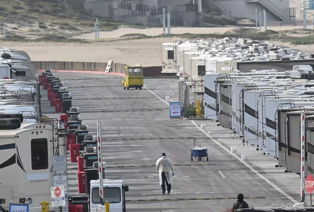 Medical staff walk among RV campers in a beachside parking lot being used as an isolation zone for people with COVID-19 at Dockweiler State Beach in Los Angeles, California © ROBYN BECK / Getty Images