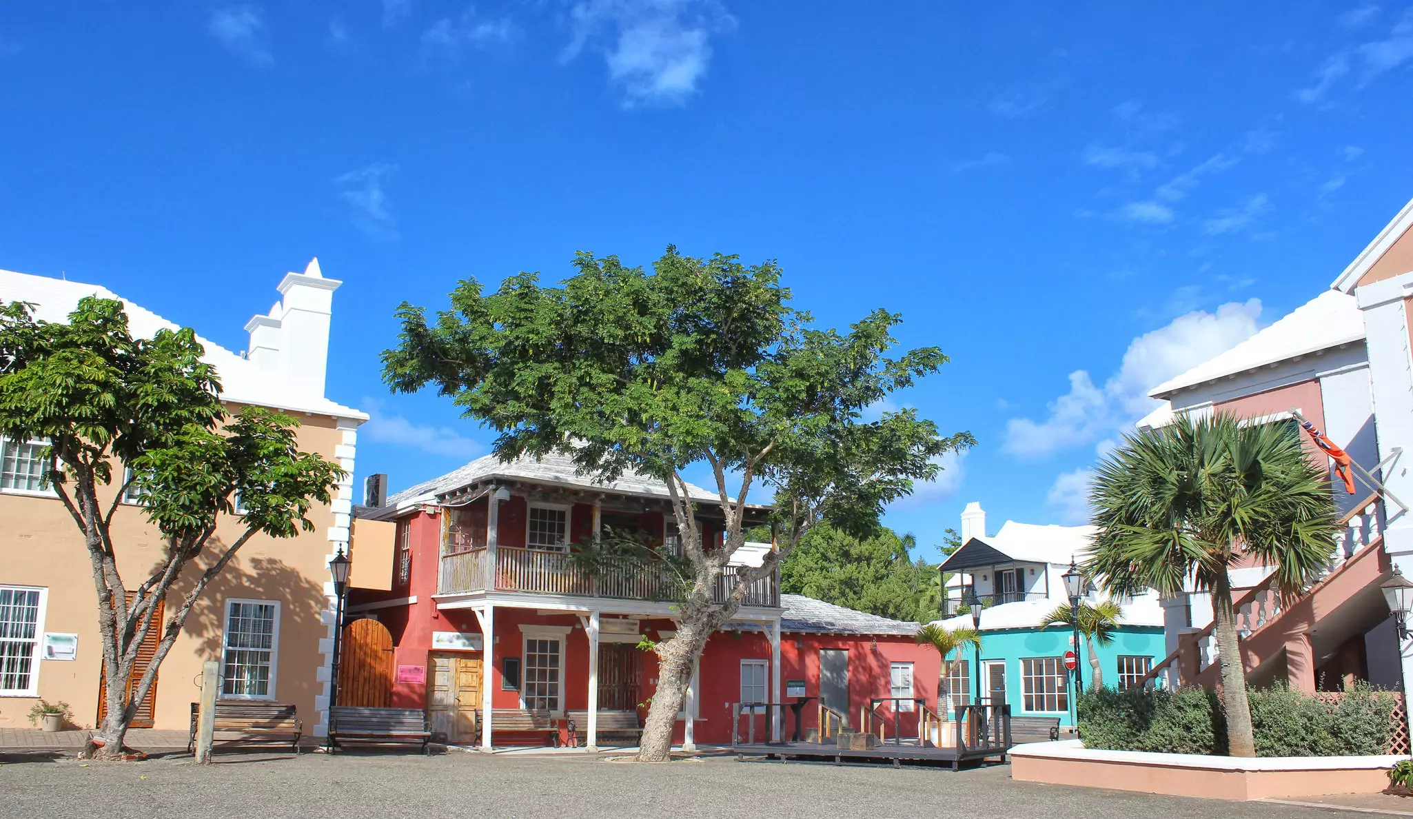A quaint historic square lined with pastel-colored low-rise buildings.