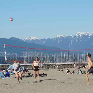 Beach Volleyball Game at Jericho Beach with mountain views in the distance. Vancouver, BC, Canada.