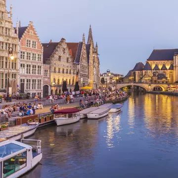 Korenlei and Graslei on the River Leie in Ghent's old town at dusk.
597070535
water, illuminated, Idyllic, promenade, waterfront promenade, built structure, building, house, row of houses, Leie, city, Old Town, historic old town, Belgium, Flanders, East Flanders, Ghent, River, twilight, evening twilight, evening, outdoor, city view, Light, Travel, Travel destination, history, historical, Korenlei, vehicle, Nautical Vessel, boat, excursion boat, Graslei, illumination, Architecture, urban scene, Incidental People, landmark, sky, blue sky, waters edge, riverside, tourism, City Break, mooring area, History, In A Row, Excursion Boat, Twilight, Outdoors, Illumination, Sky, Ghent - Belgium, Building, Travel Destinations, Horizontal, Riverside, Famous Place, Mode of Transport, Historic Old Town, City, Flanders - Belgium, Promenade, Light - Natural Phenomenon, Photography, Waterfront, Twilights, 2015, Water's Edge, Color Image, House, Illuminated, Tourism, Dusk, Built Structure, Cityscape, Blue, Water