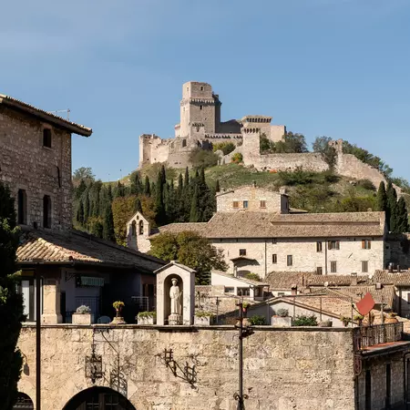 A castle towers over the stone town of Assisi