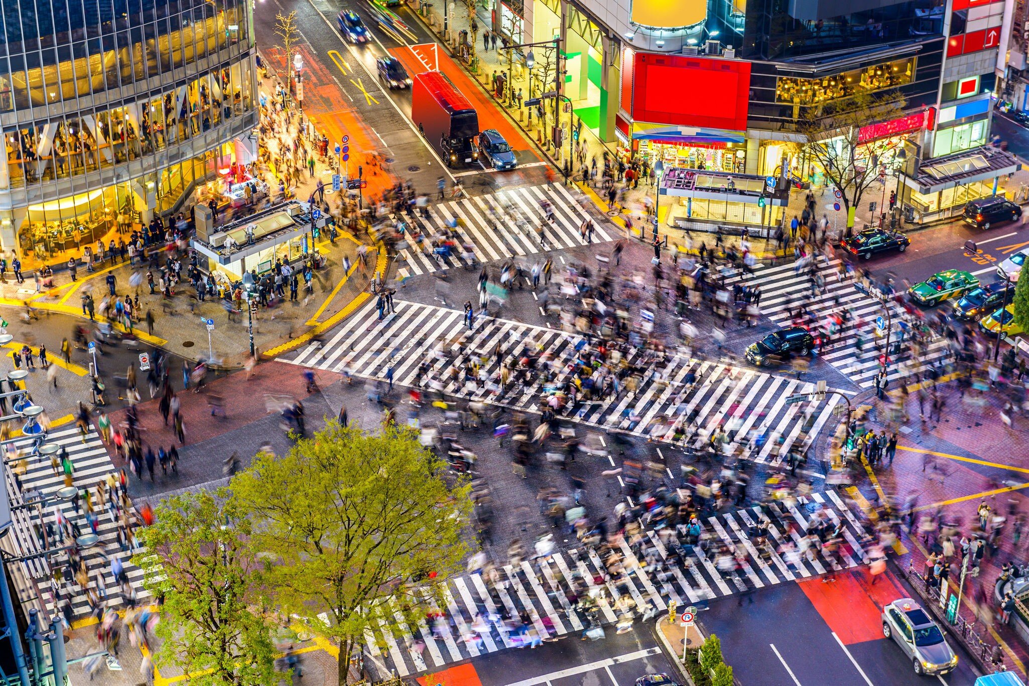 A view from above of Shibuya Crossing surrounded by billboards and shops, Tokyo, Japan.