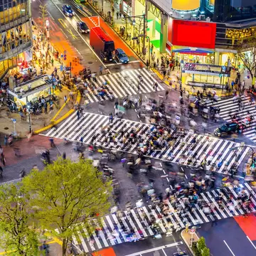 A view from above of Shibuya Crossing surrounded by billboards and shops, Tokyo, Japan.