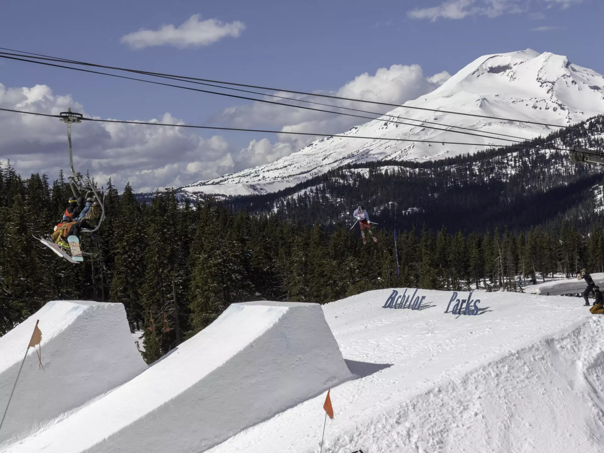 Skiers on chair lift take in big air Ski jumper at Mount Bachelor in Oregon