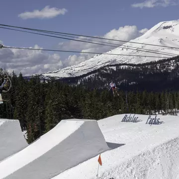 Skiers on chair lift take in big air Ski jumper at Mount Bachelor in Oregon