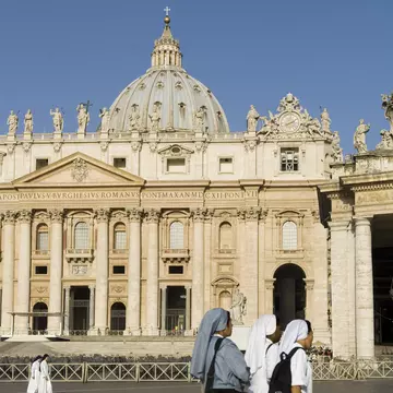 Nuns walk past St Peter's Basilica in Rome, Italy. 
