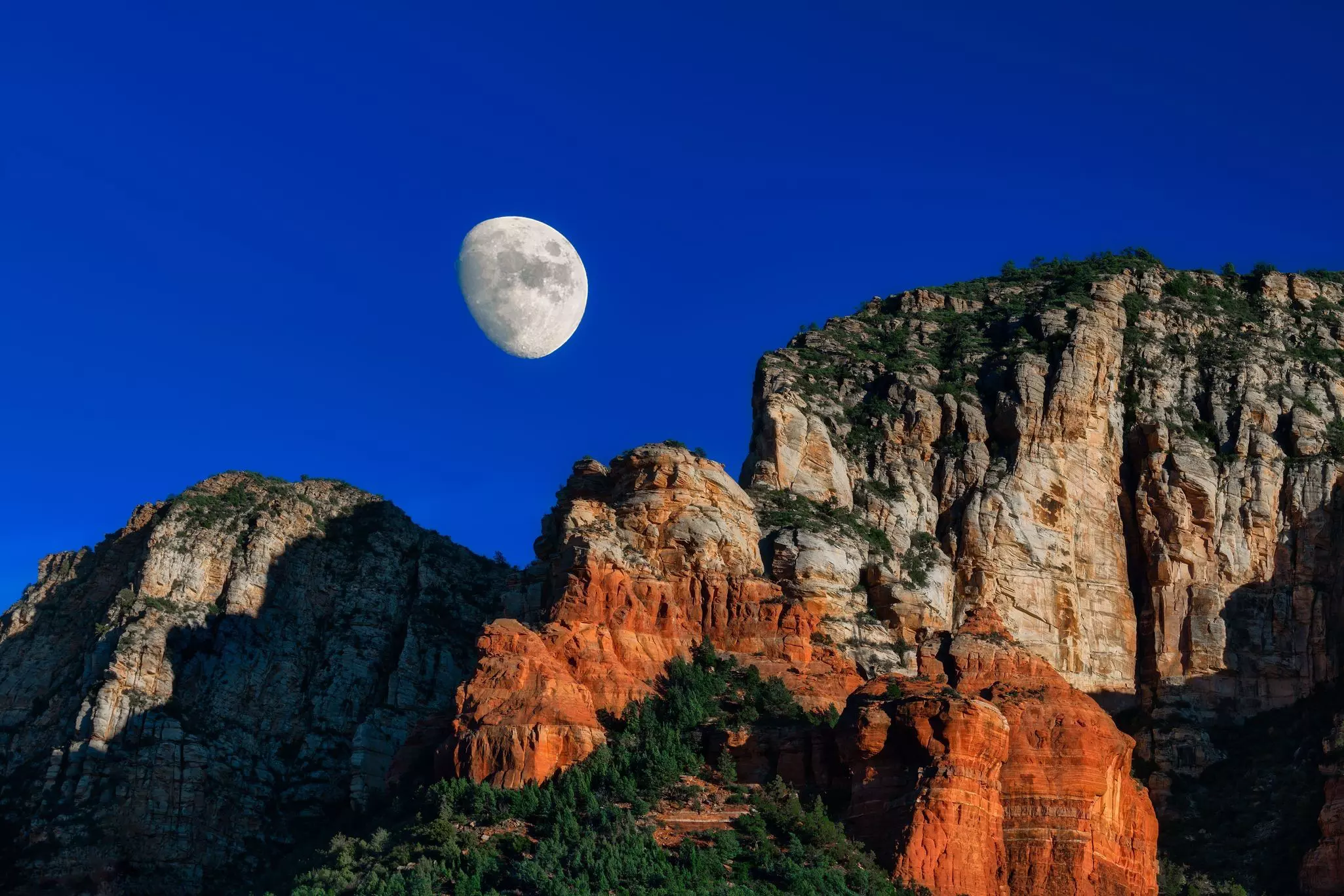 A full moon over rock formations at night, Sedona, Arizona, USA