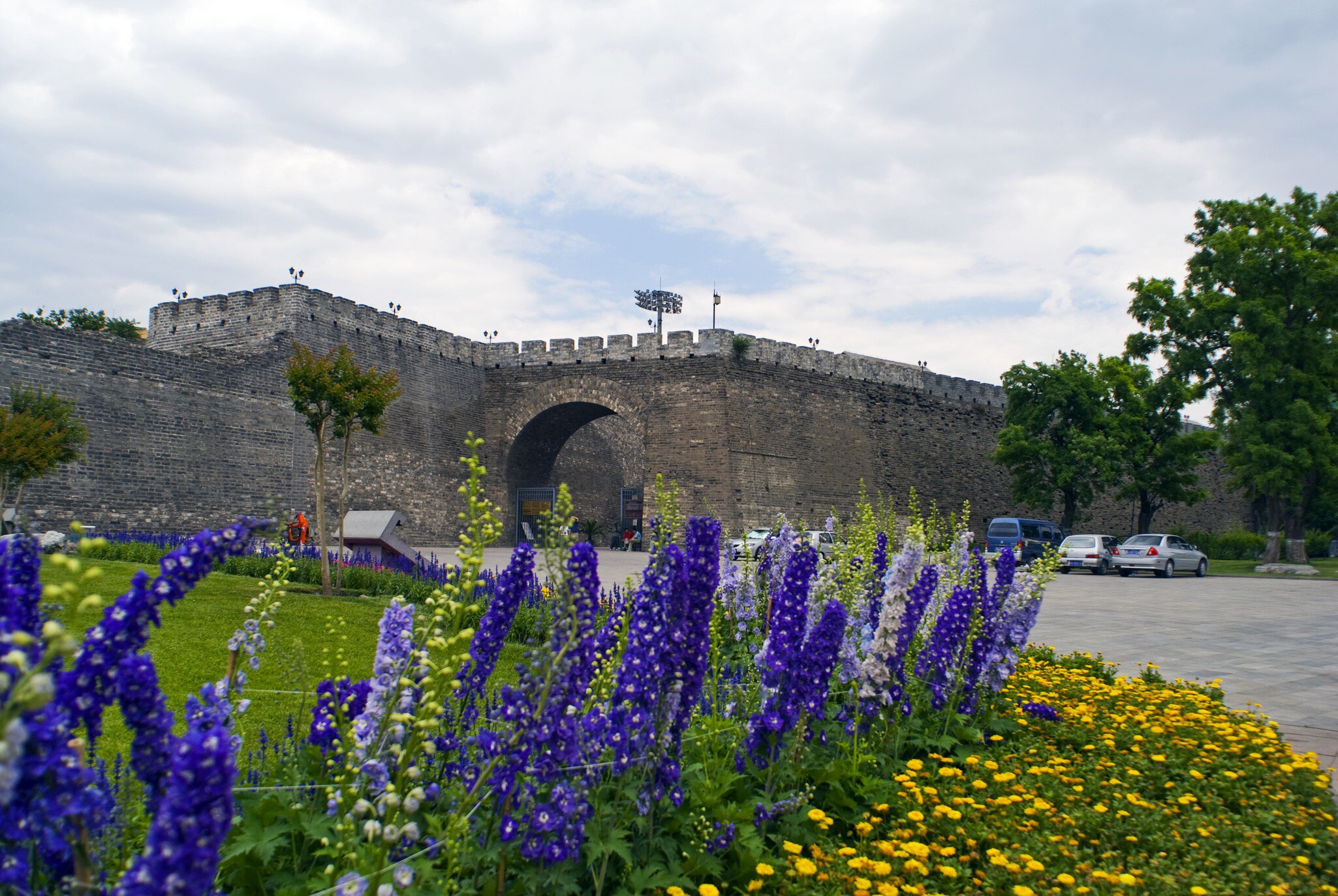 View of the Southeast Corner Watchtower, with purple flowers in foreground, in Beijing, China.