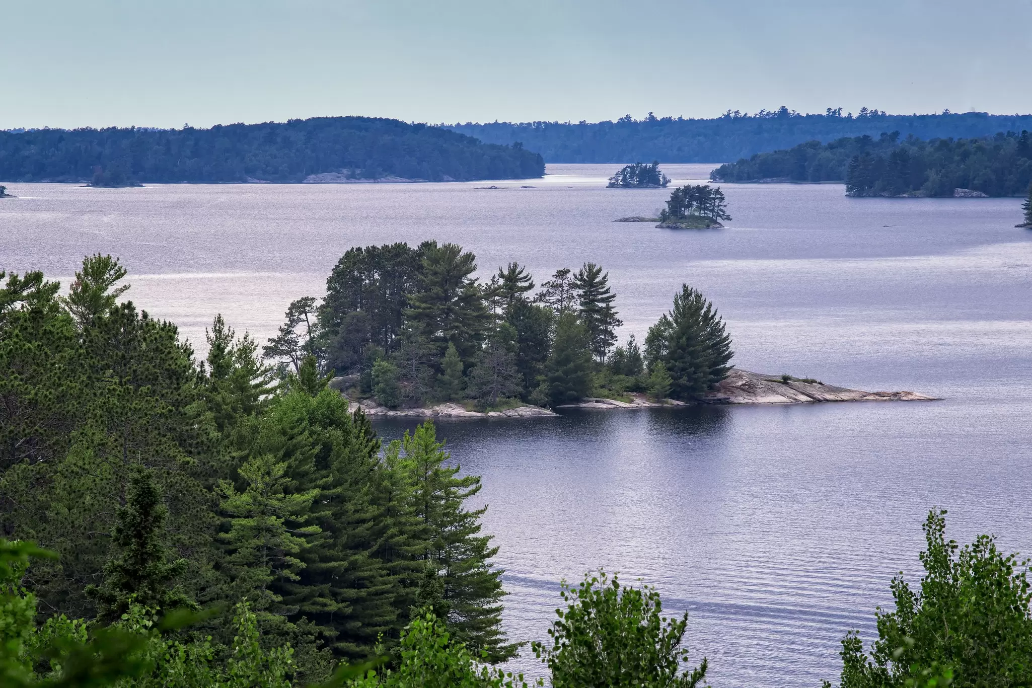 Forested islands in a lake at dusk.
