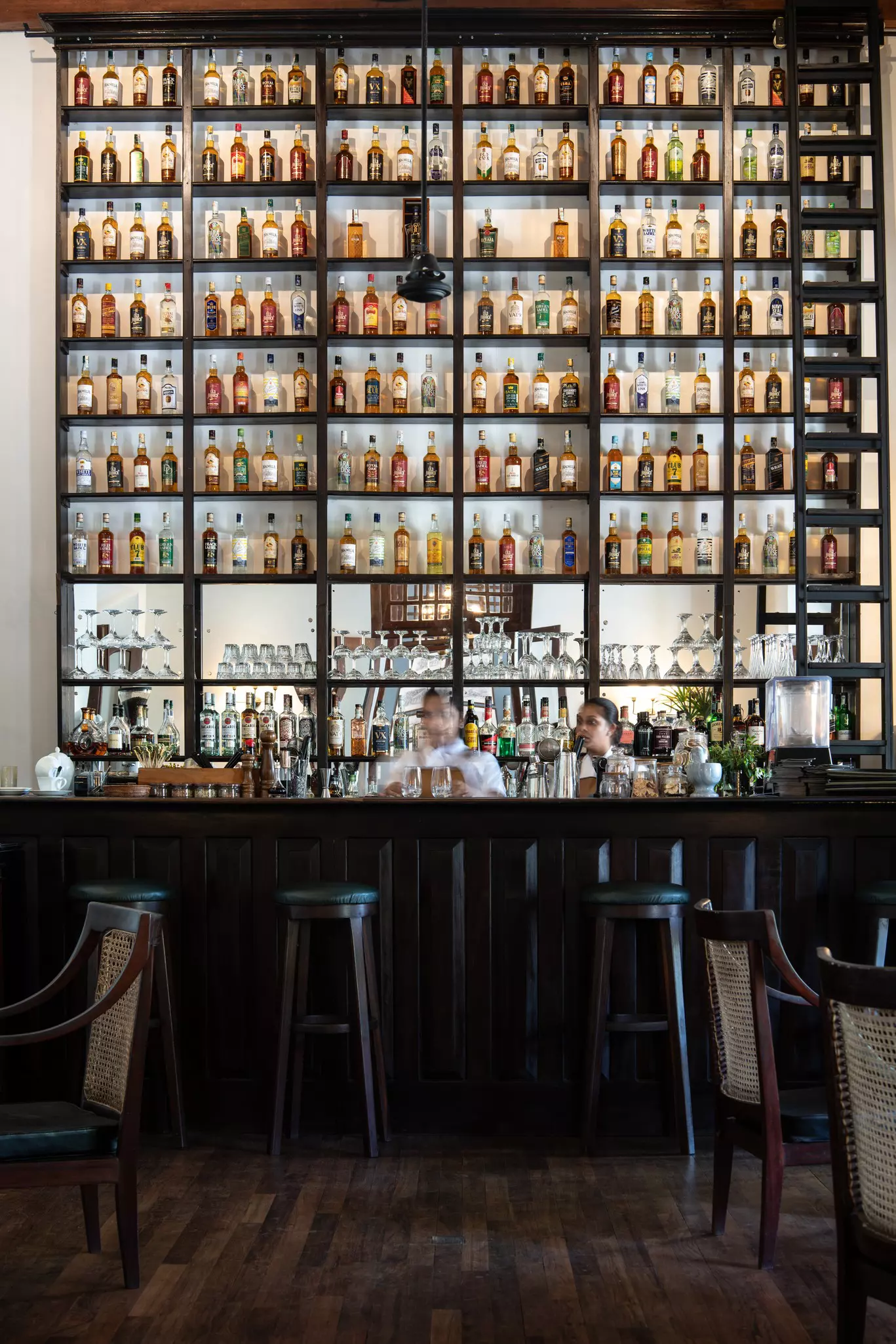 A barback filled with glass bottles of coconut spirits.