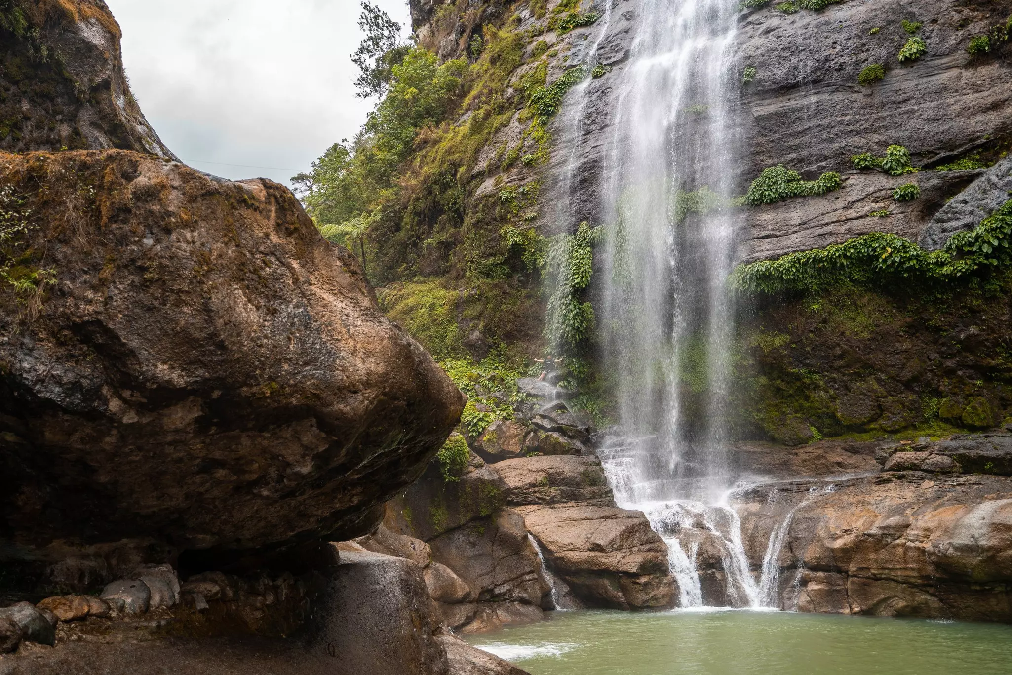 An impressive waterfall plunges down beside a cliff face.
