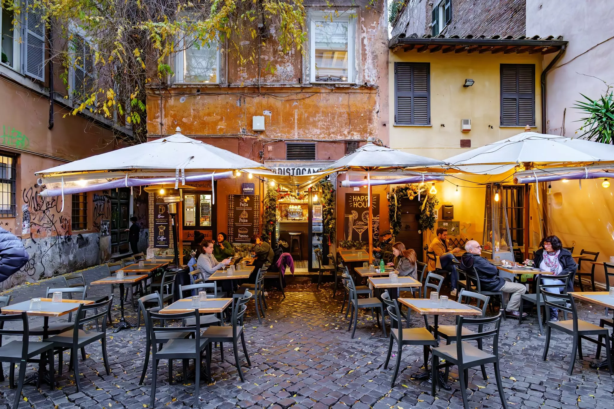 Roma, Italy.Typical tavern in the ancient Trastevere district, in Piazza della Scala. Pizzeria, sandwich shop, characteristic bar with outdoor tables and lights, in the historic center.