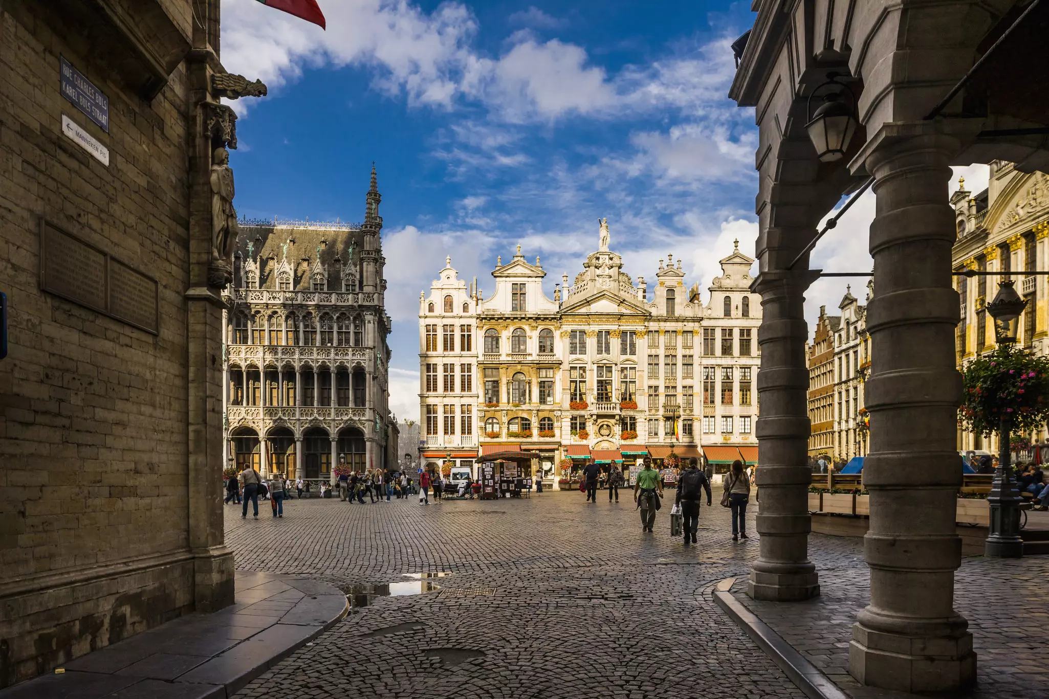 A cobblestone street leading to an open square with historic buildings.