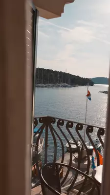 View of a sparkling sea and sailboats off a hotel balcony