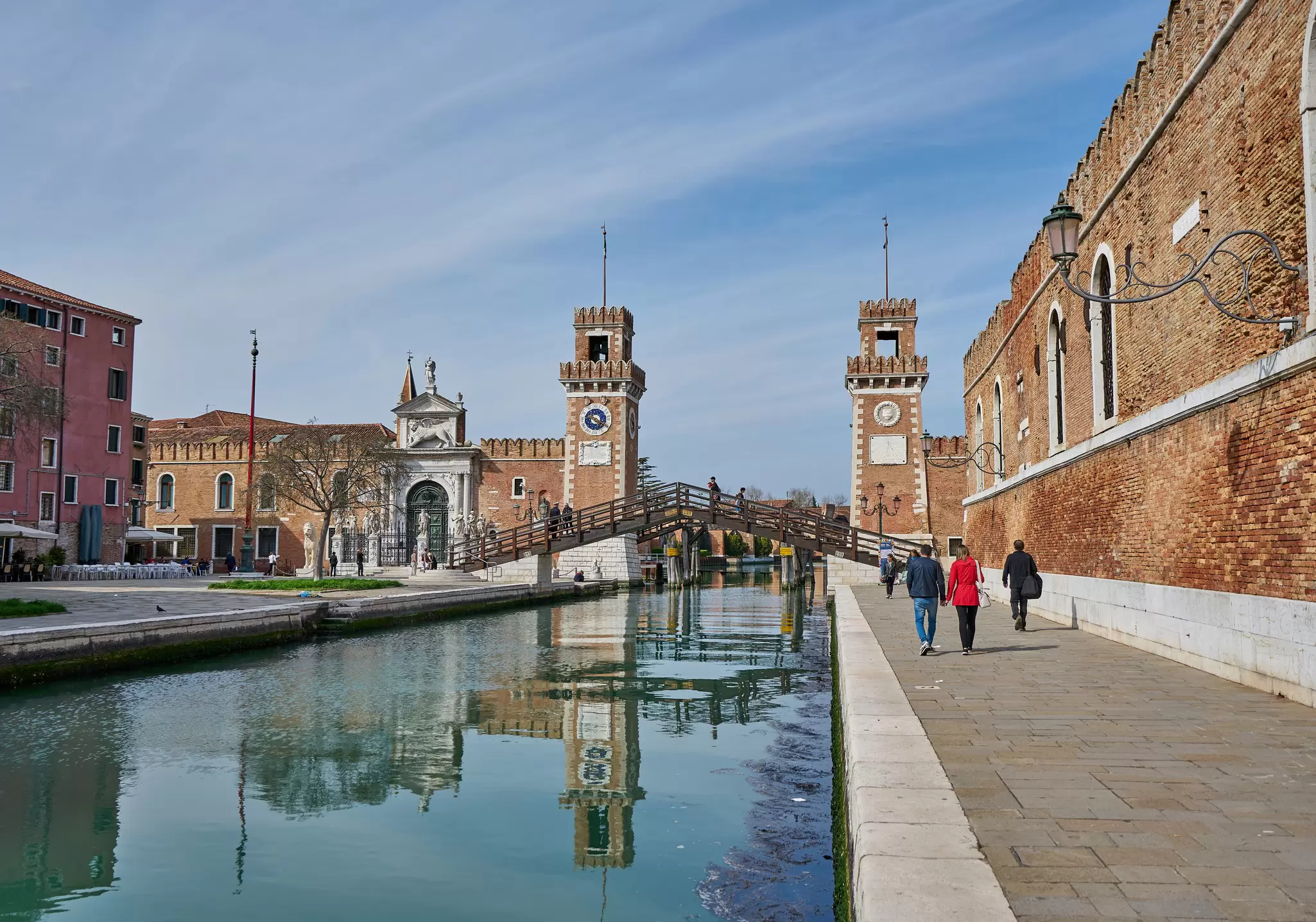 People walking by the entrance of the Arsenale in Venice, Italy.
