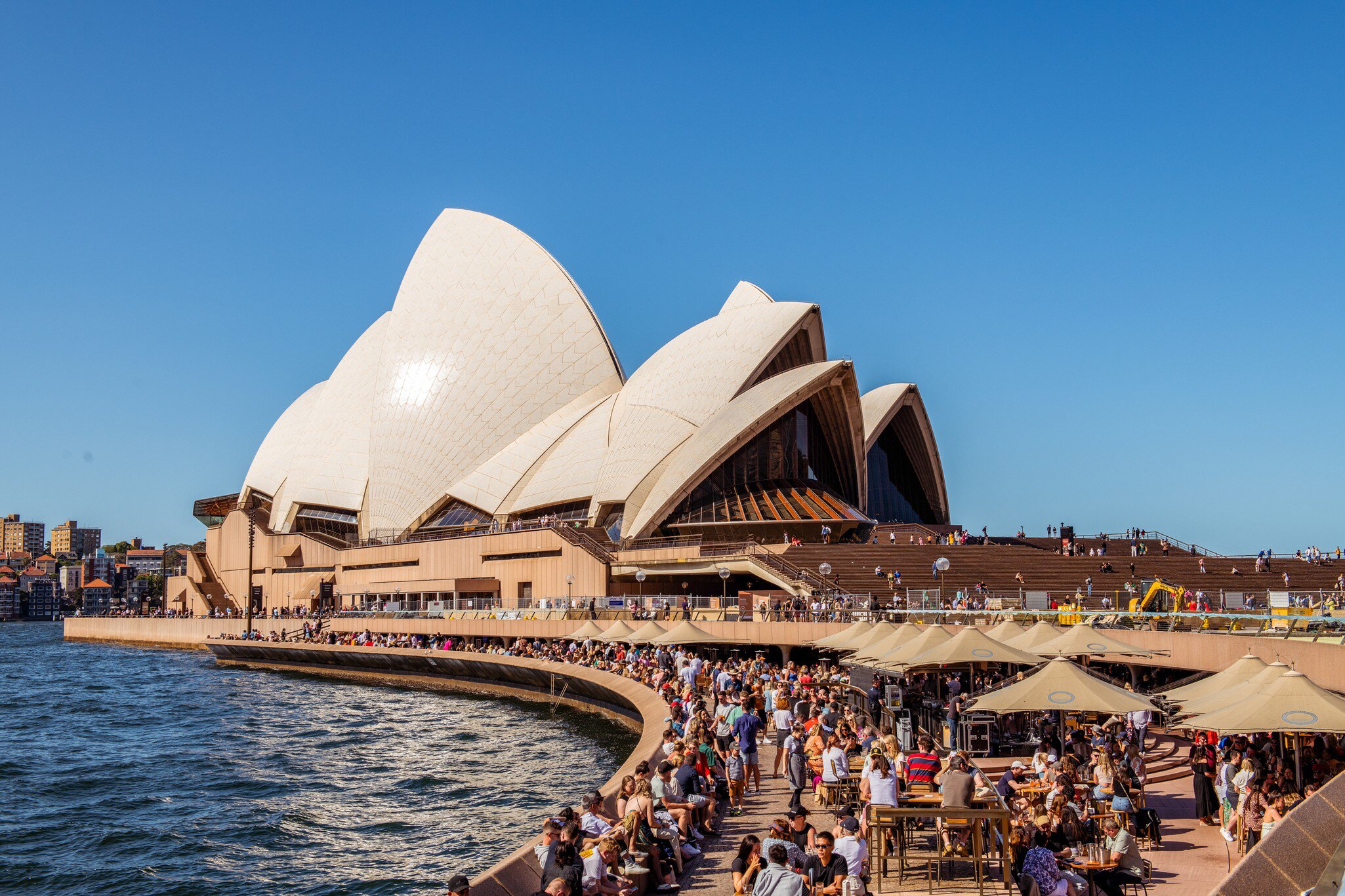 View of Sydney Harbour Bridge and Sydney Opera House with a crowd of people in Sydney, Australia.