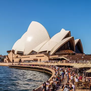 View of Sydney Harbour Bridge and Sydney Opera House with a crowd of people in Sydney, Australia.