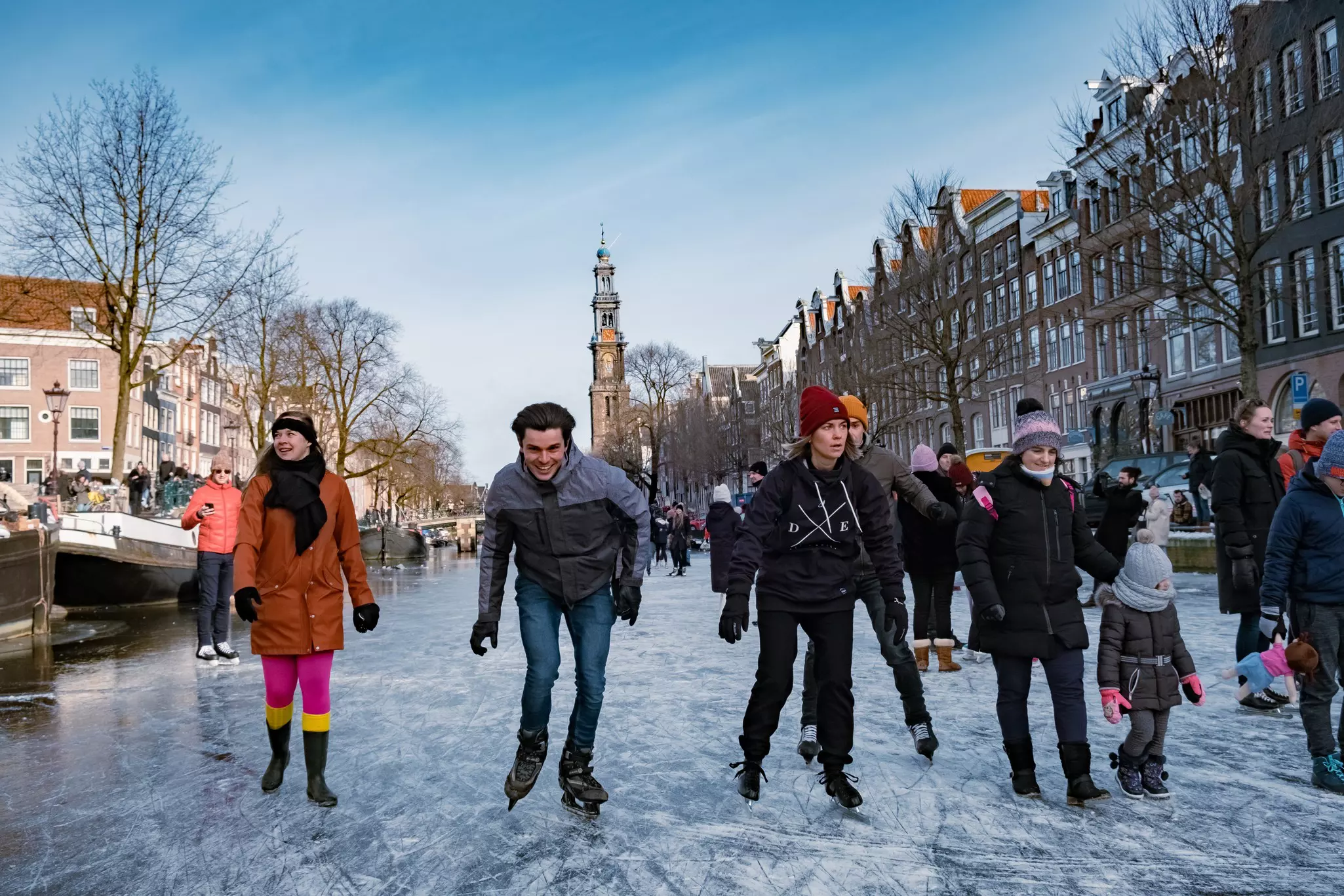 Ice-skaters on a frozen canal through central Amsterdam.