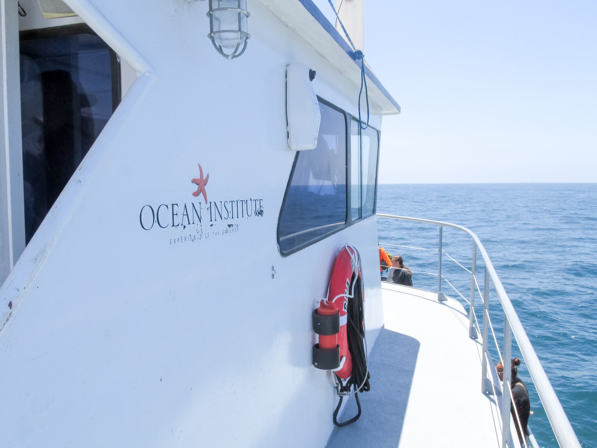 A view of of the Ocean Institute sign on the side of a whale watching boat.