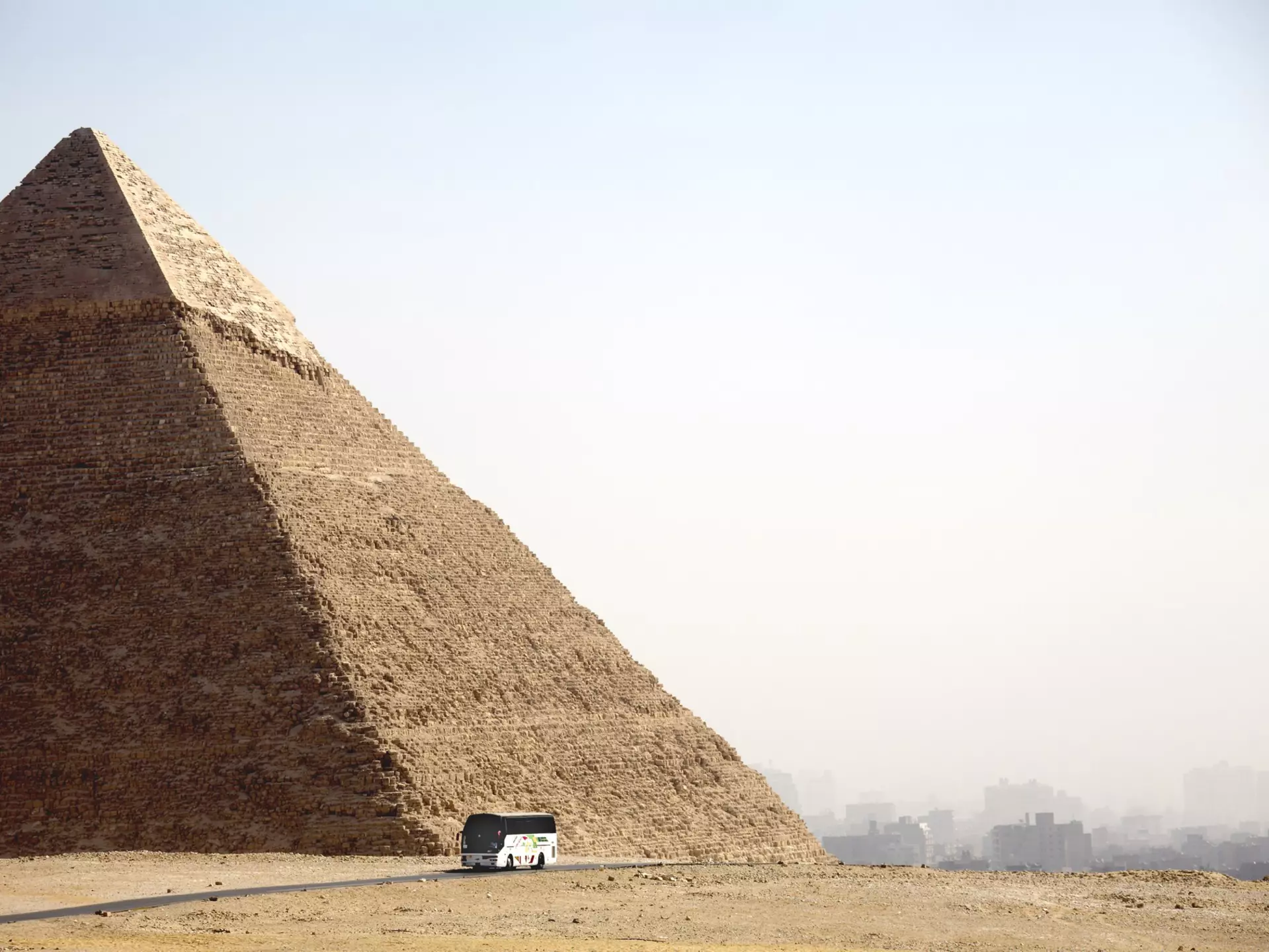 A tourist coach drives past a Pyramid in Cairo, Egypt.