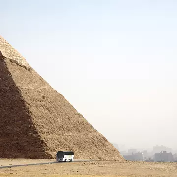 A tourist coach drives past a Pyramid in Cairo, Egypt.